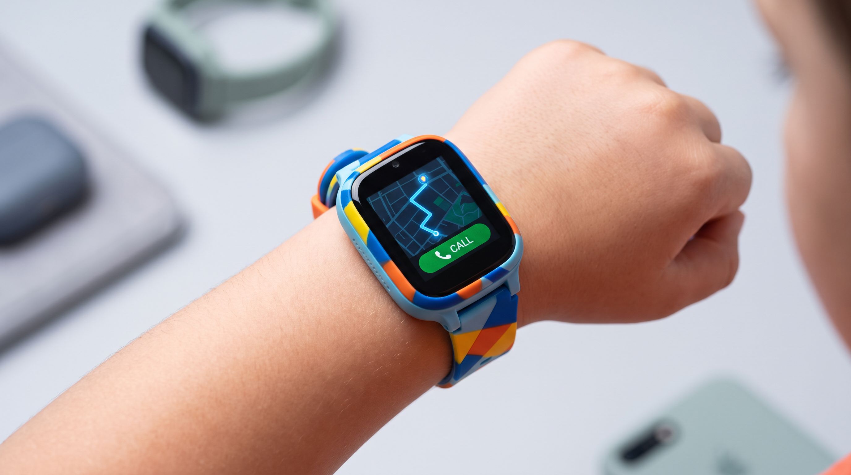 A child's wrist wearing a colorful LTE kids smartwatch showing a GPS map and call button on screen