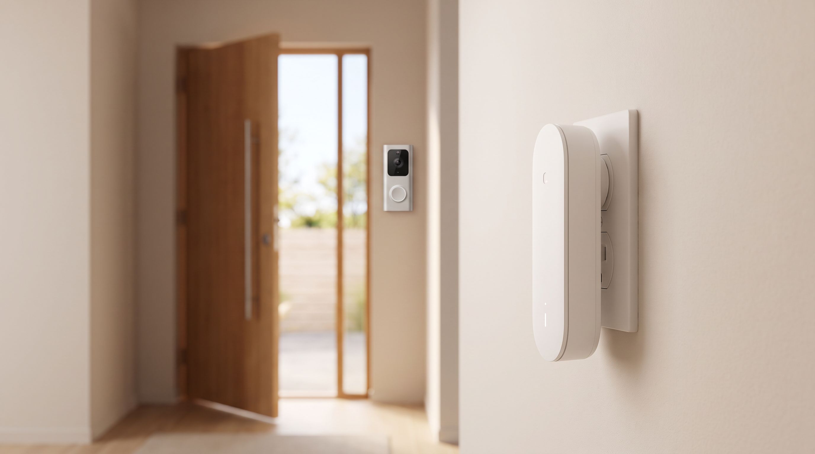 A plug-in smart doorbell chime in a hallway wall outlet with a video doorbell visible through the open front door