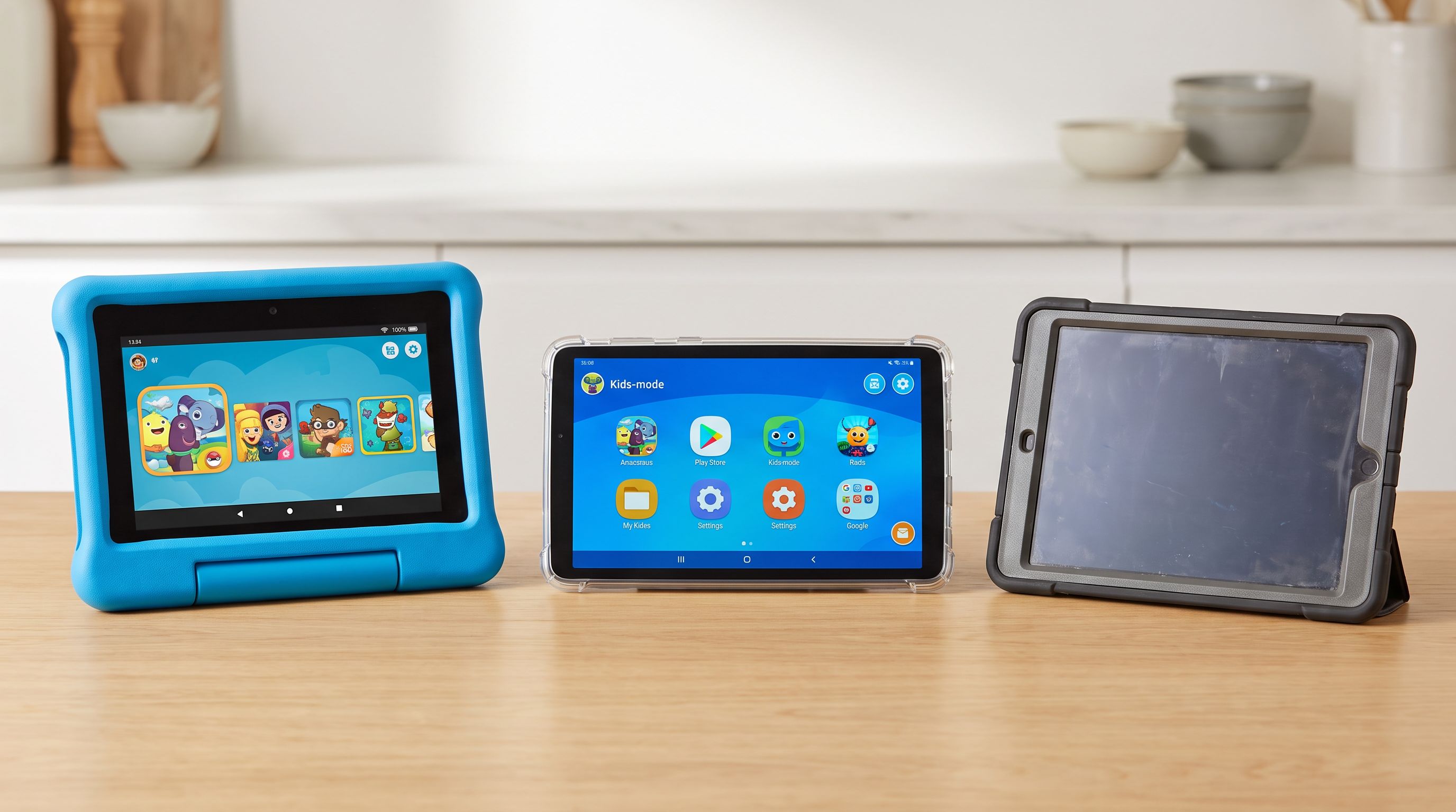 Three children's tablets side by side on a kitchen table — an Amazon Fire Kids tablet in a chunky blue foam bumper case, a Samsung Galaxy Tab with a kids-mode home screen, and an older iPad in a rugged case